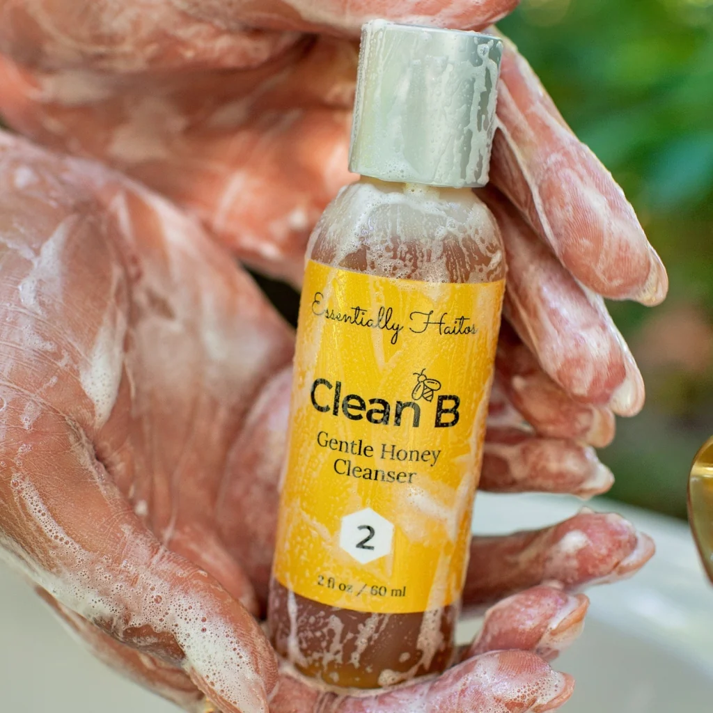 Soapy hands holding bottle of Gentle Honey Cleanser
